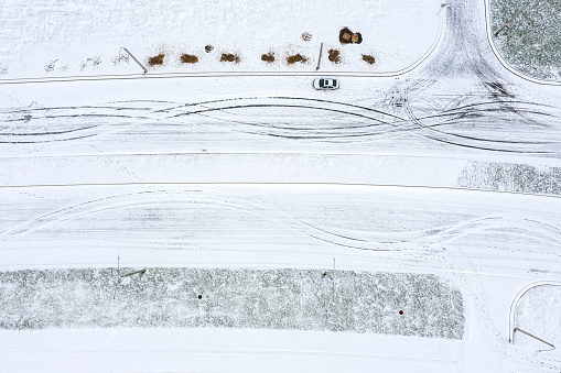 aerial view of tire tracks in snow-covered landscape. tyre imprint on snowy road surface