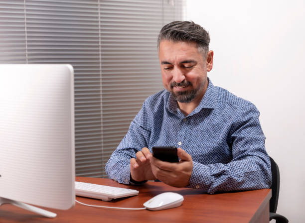 istock Portrait Of A Happy Mature Man Using Desktop Computer And Smart Phone 1206777042