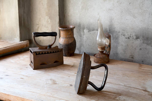istock The old iron, oil lamp and jug on a  table 120677853