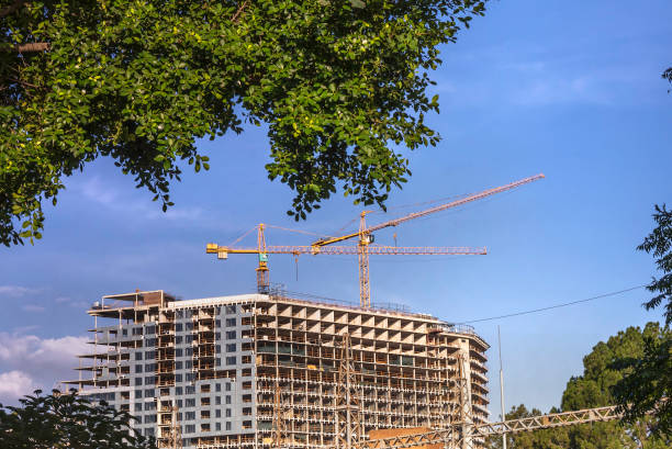 Three cranes at a new residential building under construction, in Sandton, South Africa