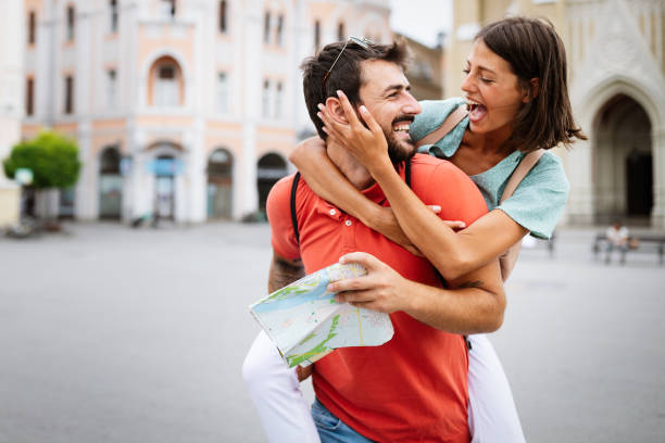 istock Happy young couple walking outdoors sightseeing and holding a map 1206781263