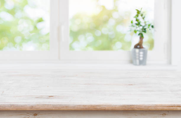 istock Wood table top and blur window background for product display 1206781968