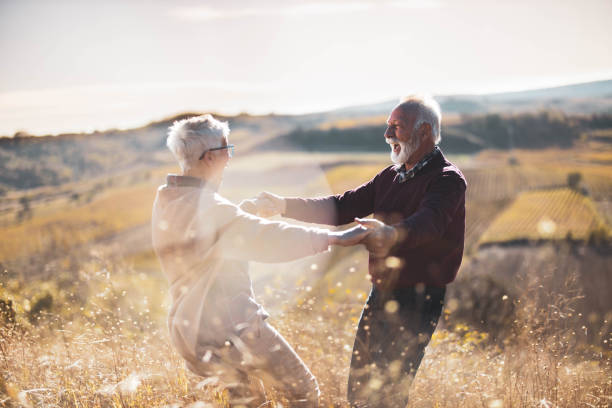 istock Playful mature couple having fun while spinning in autumn day on a hill. 1206782143