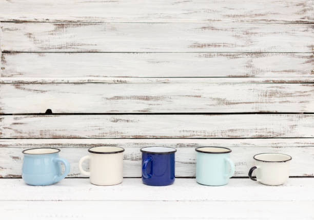 istock Enameled mugs in retro style on an old wooden background. 1206783328