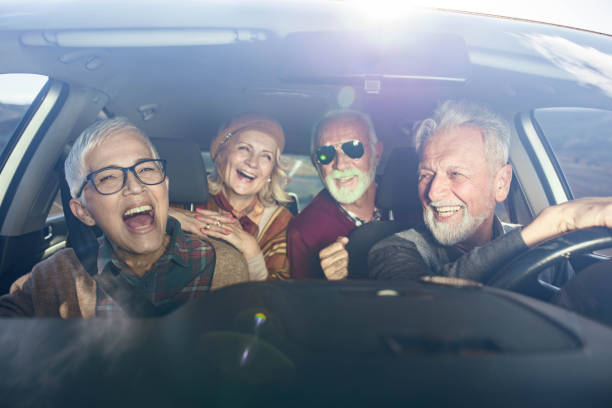 istock Group of happy seniors having fun on a road trip in a car. 1206783473