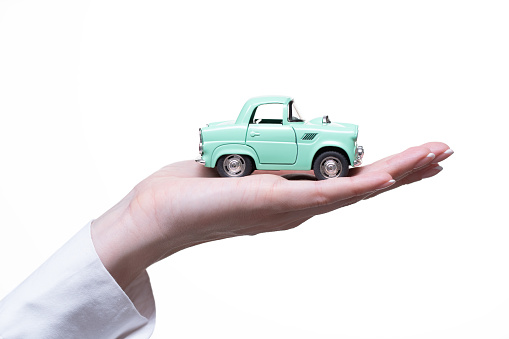 Woman holds a toy car on the palm of her hand