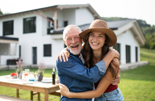 senior vater mit tochter im freien im hinterhof, blick in die kamera. - senior adult with daughter father stock-fotos und bilder