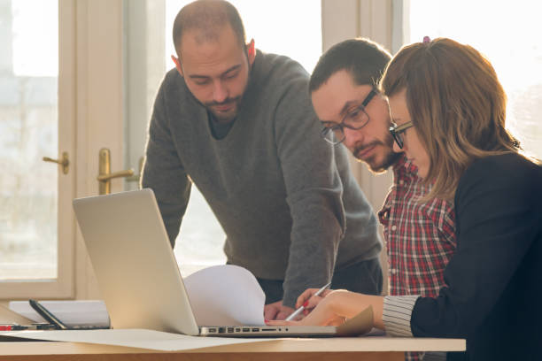 istock Group of young architects in the sunny office. 1206793360
