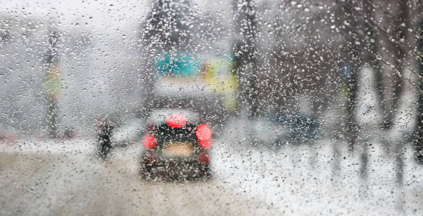 istock View from the car windscreen during rain and wet snow. Poor visibility while driving around the city. Snowy road. 1206794245