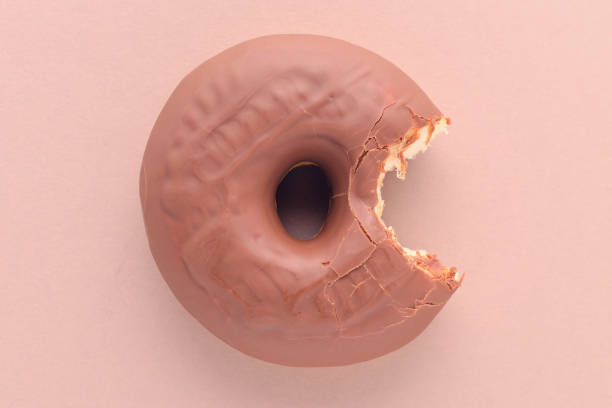 istock bitten chocolate donut on brown background, above 1206794402
