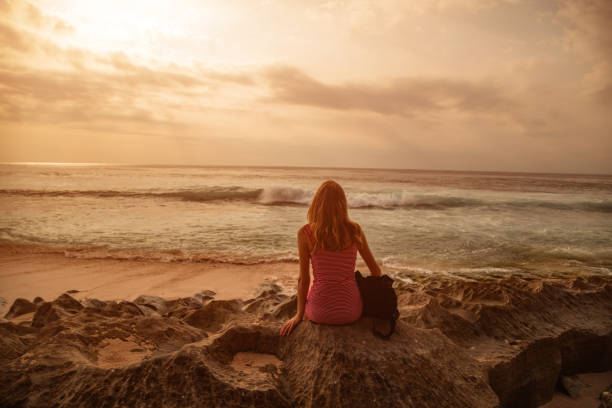 istock Woman looking at distant seascape from the beach. 1206795661