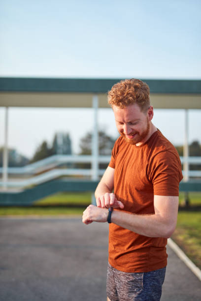 istock Young man using hand watch during exercising / stretching in urban park. 1206796040
