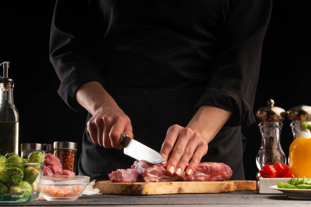 istock The chef cuts fresh pork for cooking. Against the background of vegetables. Kulinapiya, Restaurant business, recipes 1206796364