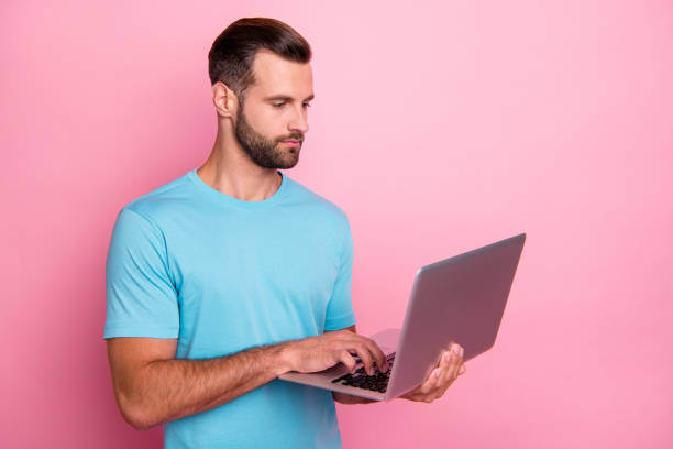 istock Photo of serious man looking puzzled into lap top electronic device using wireless internet connection isolated pastel color background 1206796885