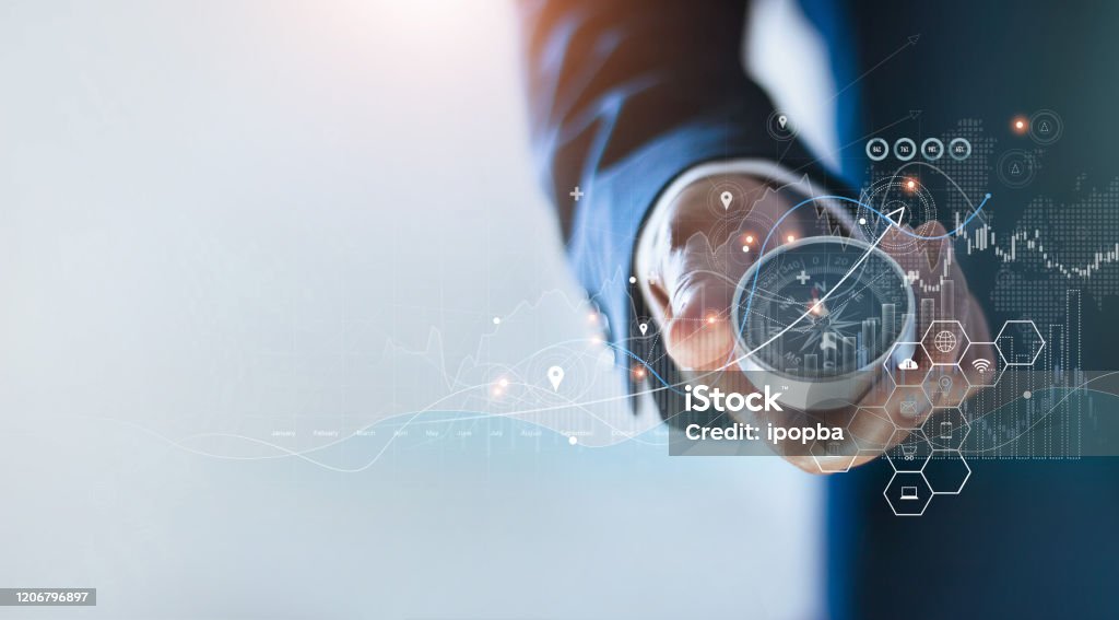 Businessman holding a navigation compass in hand and define marketing direction and analysis growth sale data with search customer global network, Abstract business. Navigational Compass Stock Photo