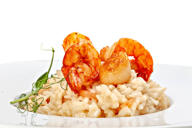 Seafood risotto in plate decorated with microgreens sprig.