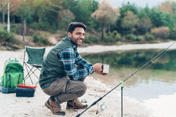 istock Young man fishing by a lake 1206799080