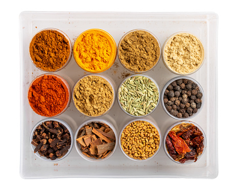 Colorful  spices in plastic containers isolated on white. Indian spice set. Top view.