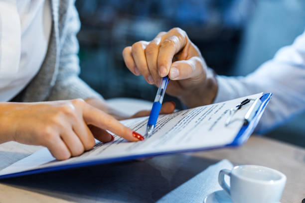Sign here! Close up of unrecognizable insurance agent showing his customer where to sign the contract. lease agreement stock pictures, royalty-free photos & images