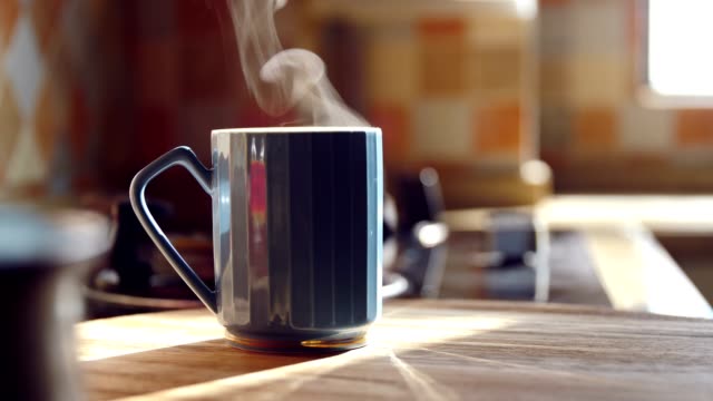 Hot coffee with steam on table