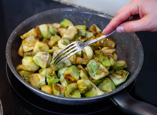 Photo of Fried peeled artichokes in a pan