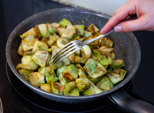 fried peeled artichokes in a pan - artichoke vegetable macro close up imagens e fotografias de stock