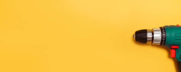 istock Heavy drill or screwdriver on a yellow background with copyspace 1206808229