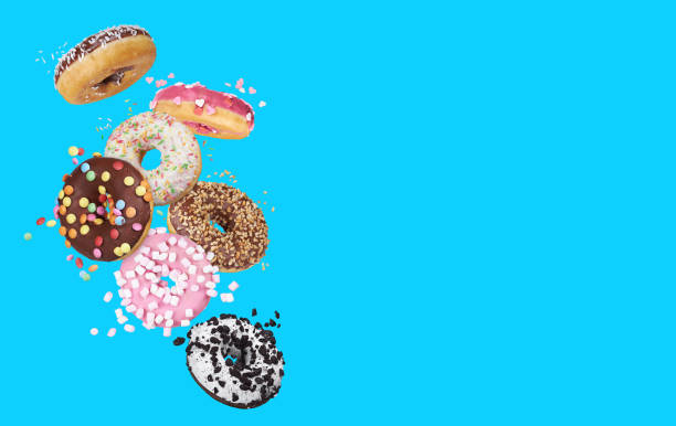 istock flying glazed round doughnuts. Mix of multicolored sweet donuts 1206808424