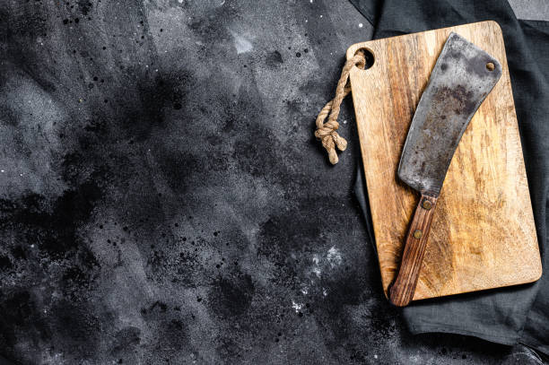 Meat cleaver on old scratched wooden cutting Board. Dark background. Top view. Copy space Meat cleaver on old scratched wooden cutting Board. Dark background. Top view. Copy space. mezzaluna stock pictures, royalty-free photos & images