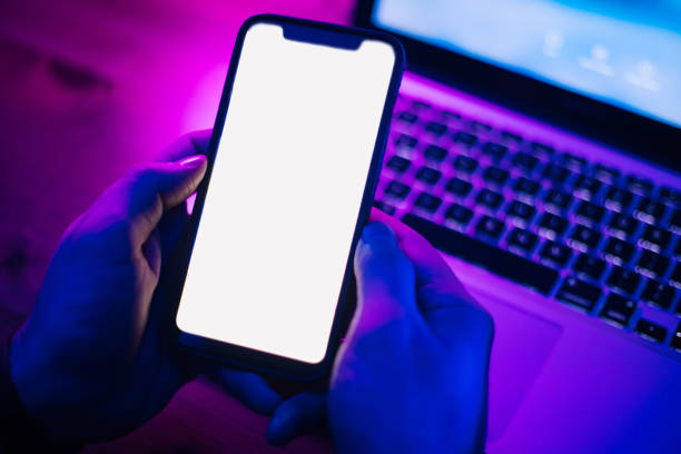 istock Top view of using smartphone in purple neon light 1206810727