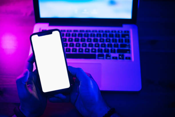 istock Top view of using smartphone in purple neon light 1206810738