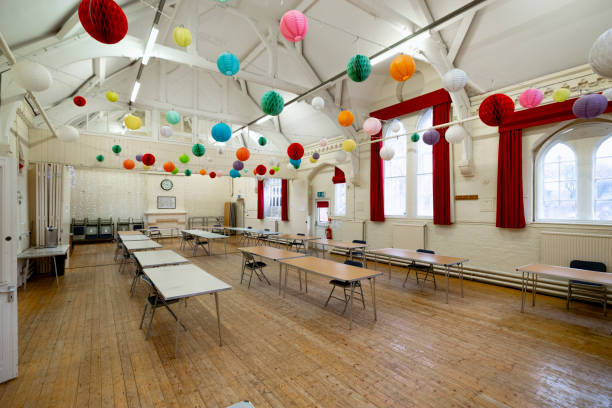 Brightly Decorated Community Hall A community space is decorated with brightly coloured honeycomb paper decorations. It looks welcoming and set up for a party or gathering. / Female Focus Collection community center stock pictures, royalty-free photos & images