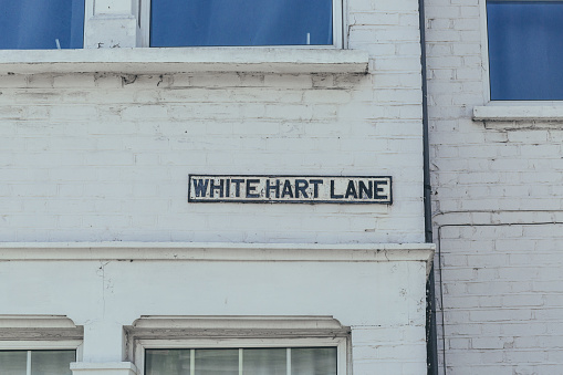 White Hart Lane name sign on a brick wall in Barnes, district in the London Borough of Richmond upon Thames, UK