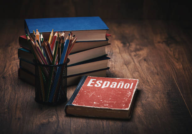 istock learn Spanish. Book on a wooden table 1206811522