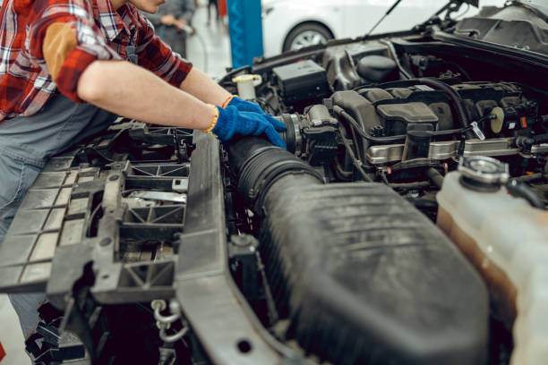Caucasian female mechanic replacing a radiator hose Cropped photo of a technician repairing the cooling system in the car cooling rack photos stock pictures, royalty-free photos & images