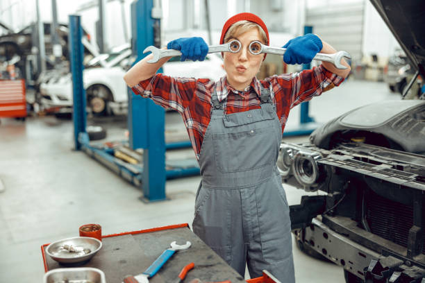 Caucasian girl holding a pair of spanners Young car mechanic pulling funny faces in the workplace wrench photos stock pictures, royalty-free photos & images