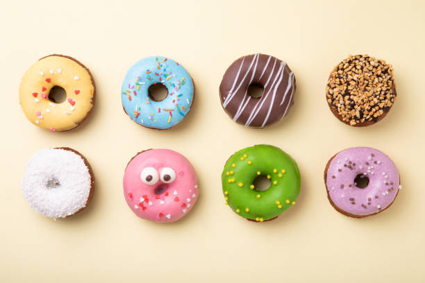 top view of set of donuts on yellow background. flat lay, copy space. - sweet food sugar vibrant color multi colored imagens e fotografias de stock