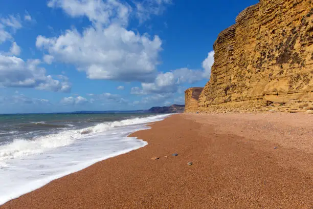 Jurassic coast England UK Freshwater beach near West Bay with waves and sandstone cliffs