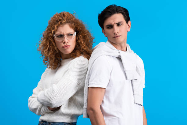 istock irritated girlfriend and offended boyfriend standing back to back, isolated on blue 1206820554