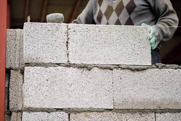 istock Close-up of construction worker builds brick wall 1206822264