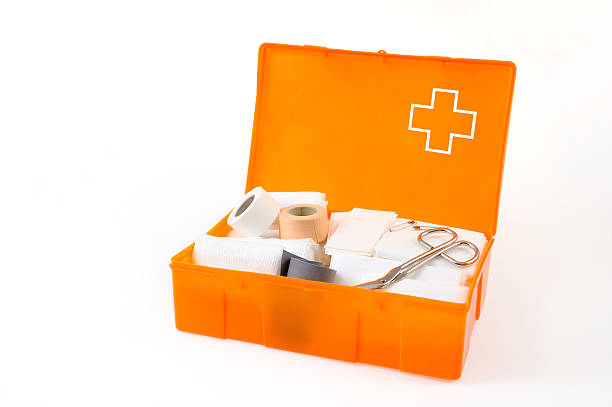 Orange first aid box with bandages, gauze, and scissors stock photo