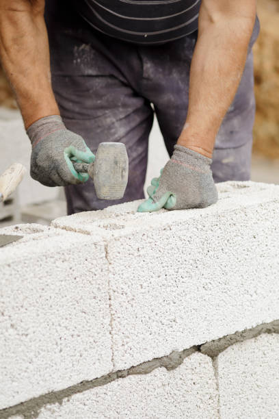 istock Close-up of construction worker builds brick wall 1206822663