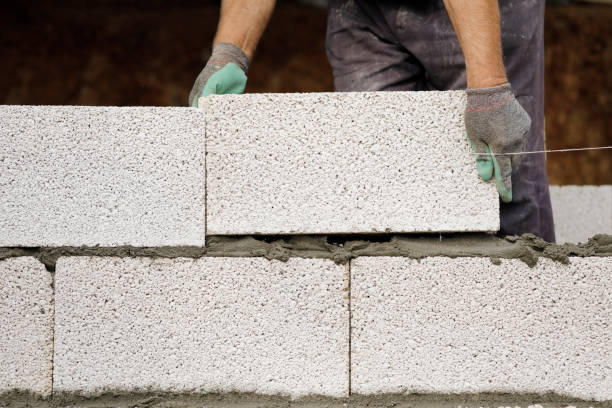 istock Close-up of construction worker builds brick wall 1206823675