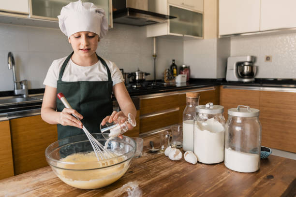istock Little girl preparing cakes 1206824685