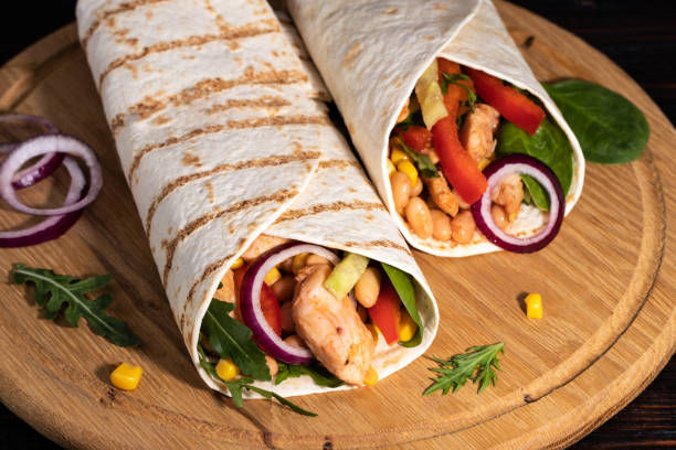 istock Burritos wraps with chicken and vegetables on dark background. Mexican food 1206824723
