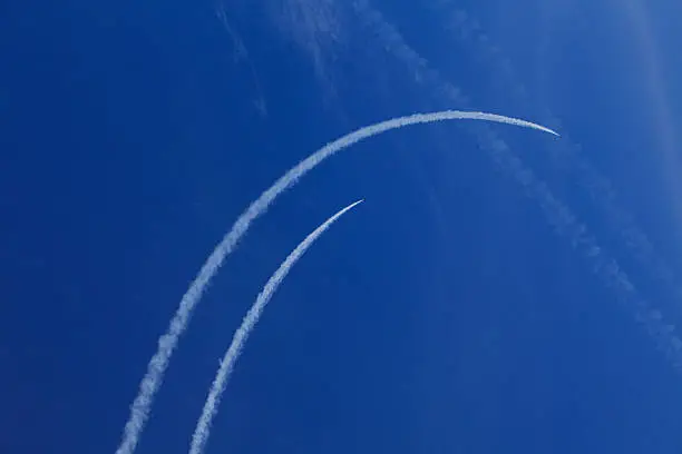 Jet-fighter traces against bright blue sly
