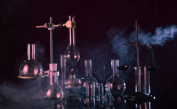 istock Laboratory glassware, chemical scales, tripod and a torch on dark background 1206825526