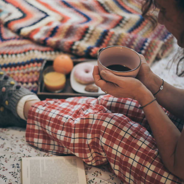 istock Midsection Of Woman Holding Coffee Cup On Bed 1206825573
