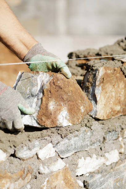 istock Close-up of construction worker builds stone wall 1206827451