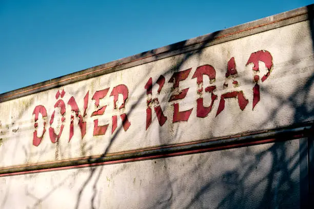 Photo of Close - up of the words Döner Kebap (english: doner kebab ) on an old trailer against blue sky